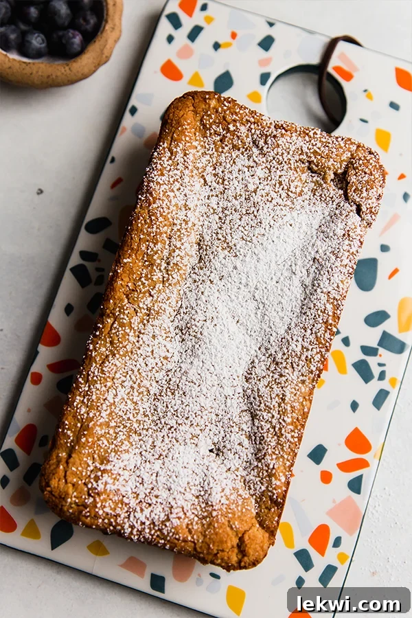 Loaf of applesauce pound cake on a colorful dish.