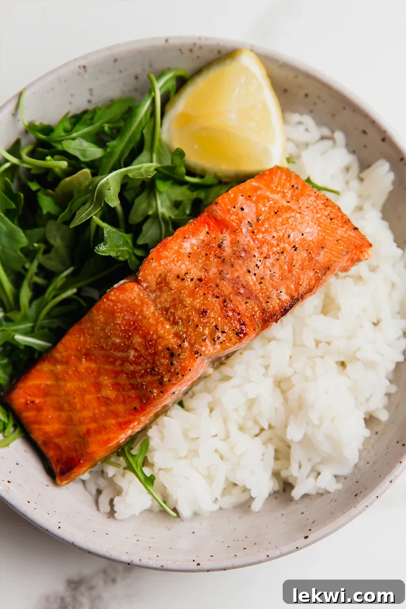 Plate of salmon, rice, and greens. A complete healthy meal.