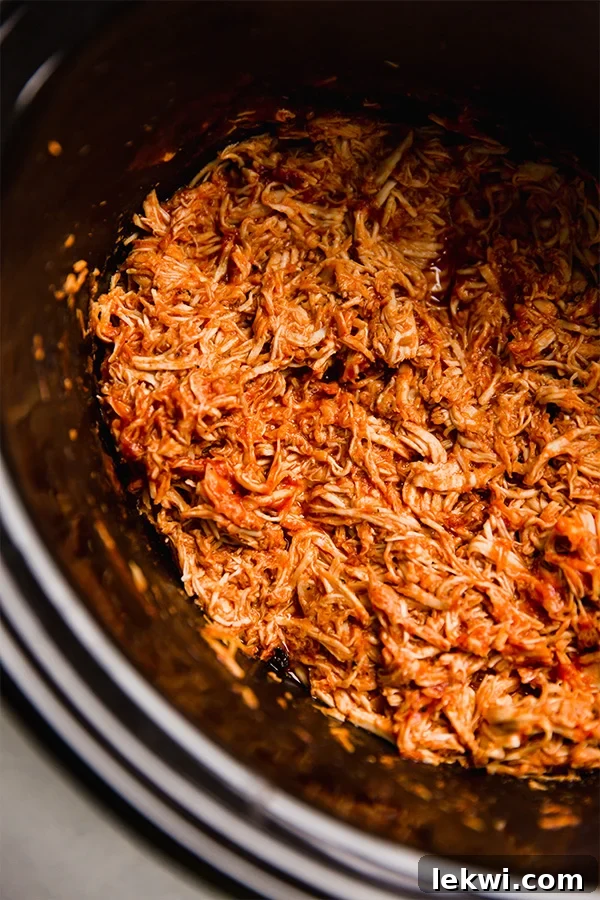 Shredded BBQ chicken in a slow cooker, cooked to perfection.