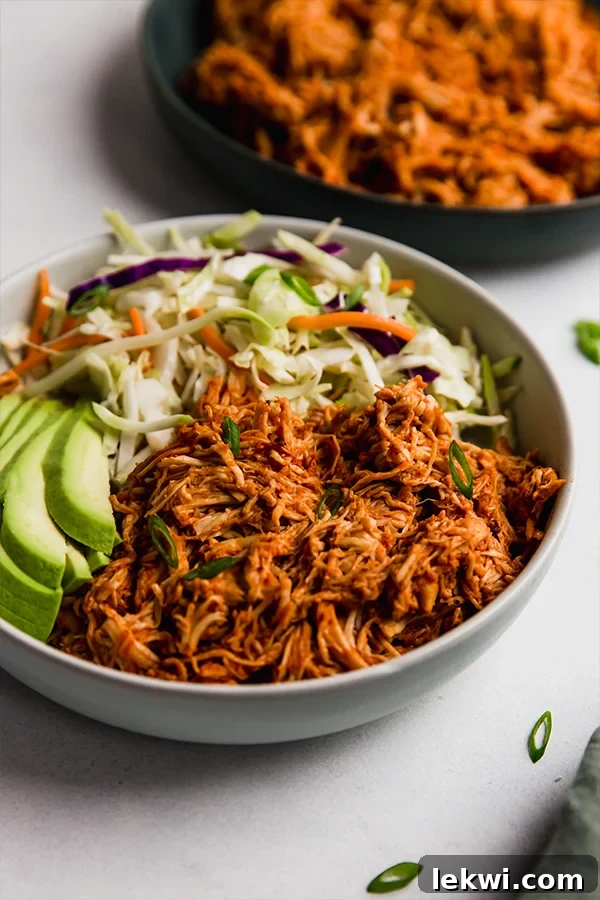 Bowl of vegetables and shredded barbecue chicken. A delicious and healthy meal for any occasion.