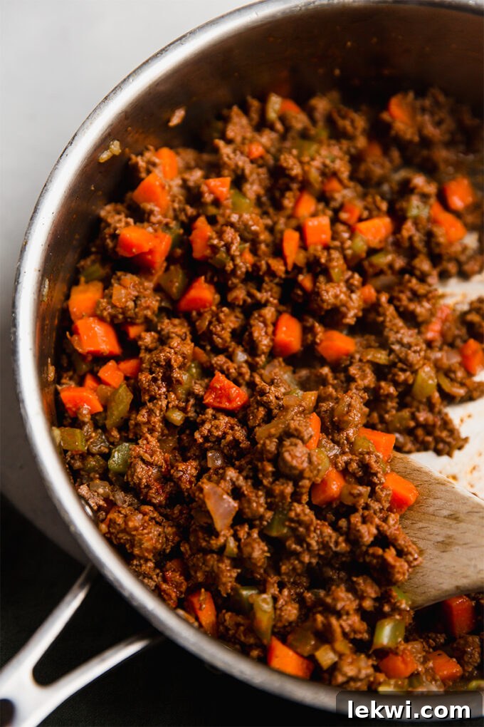The savory ground beef and vegetable filling simmering in a large skillet on the stovetop.