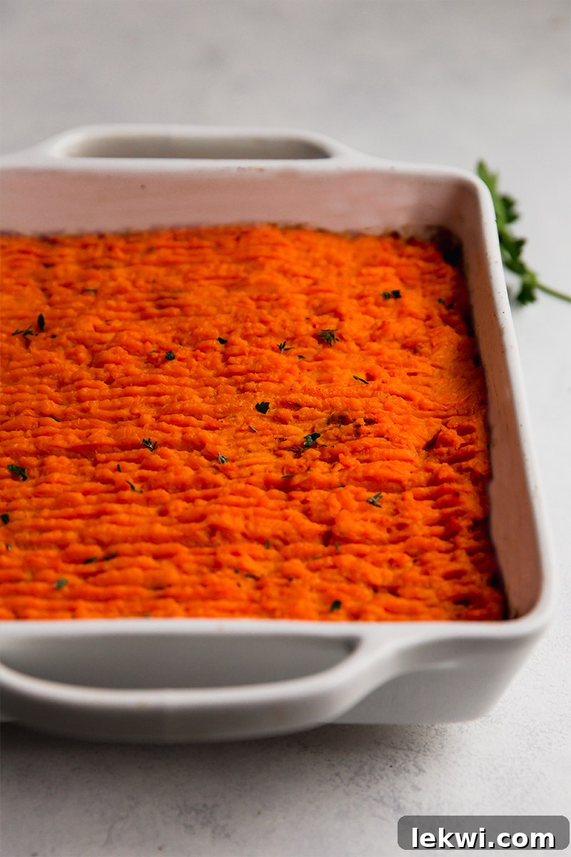 Close-up of a baked sweet potato shepherd's pie with a golden, crisp topping in a baking dish.