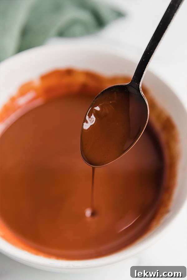 Smooth, melted chocolate mixture glistening in a glass bowl.
