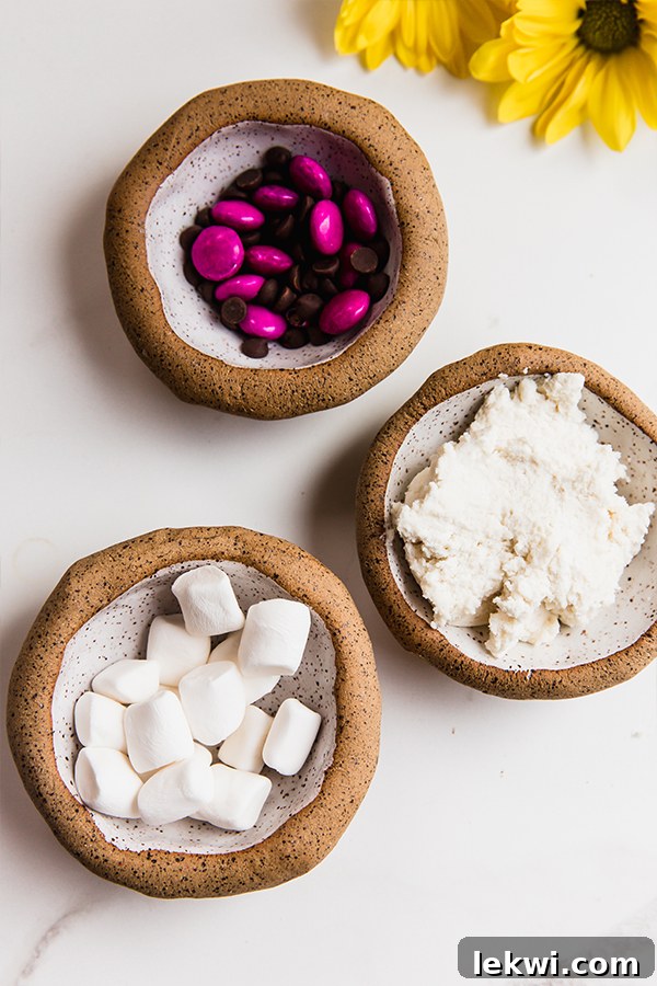candy, frosting and marshmallows in bowls