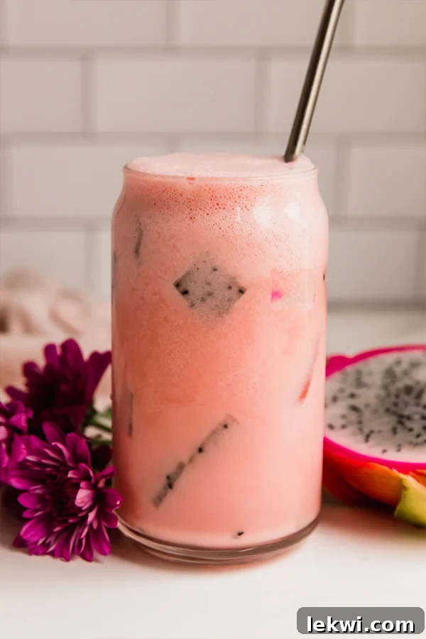 Dragon fruit drink in a glass with a straw.