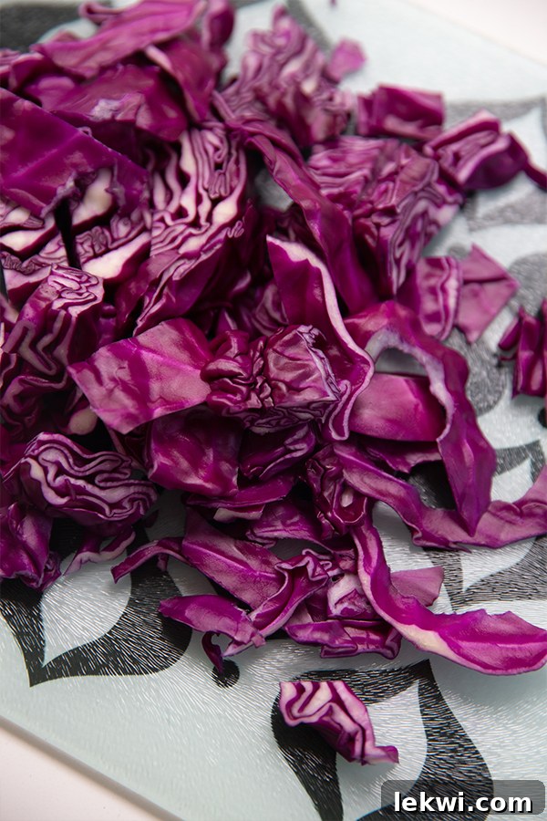 Finely shredded purple cabbage on a wooden cutting board, ready for dye preparation.