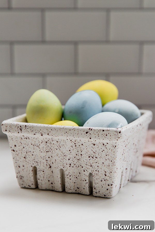 A charming display of naturally dyed Easter eggs in various shades, nestled gently in a rustic egg carton, ready for display or gifting.