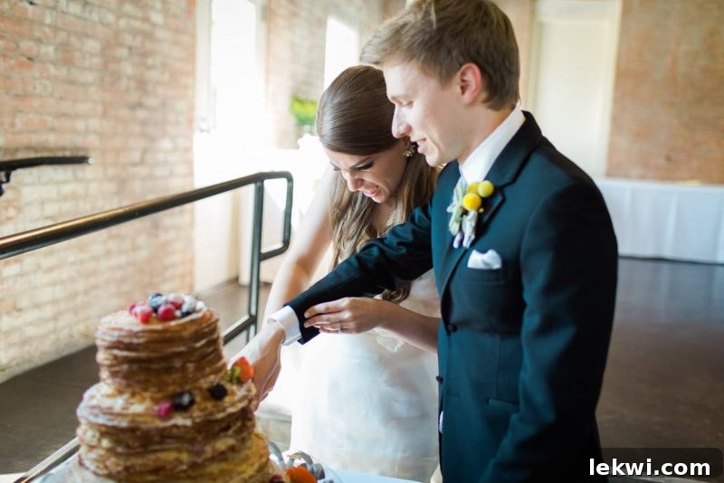 Wedding cake being cut by the bride and groom