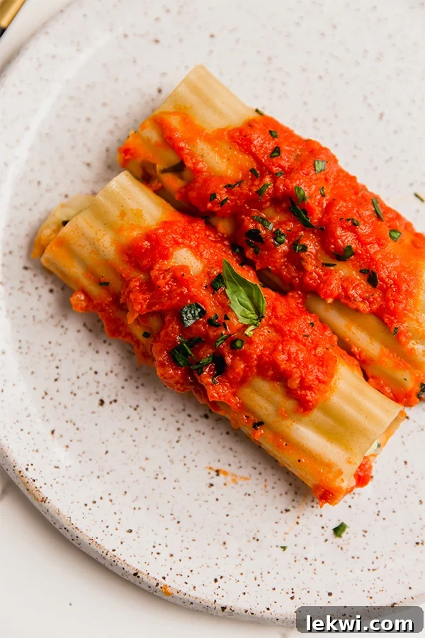 Gluten-Free Cauliflower Manicotti served on a plate with sauce, garnished with fresh herbs.