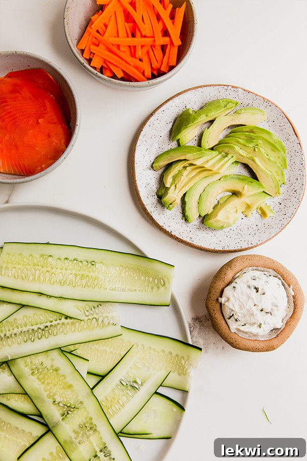The ingredients for smoked salmon cucumber bagel rolls including cucumber, smoked salmon, dairy-free cream cheese, avocado, and bagel seasoning.