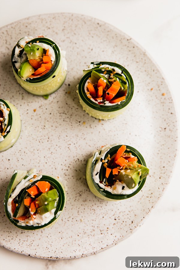 Several smoked salmon bagel cucumber rolls on a plate, elegantly arranged and ready to be enjoyed.