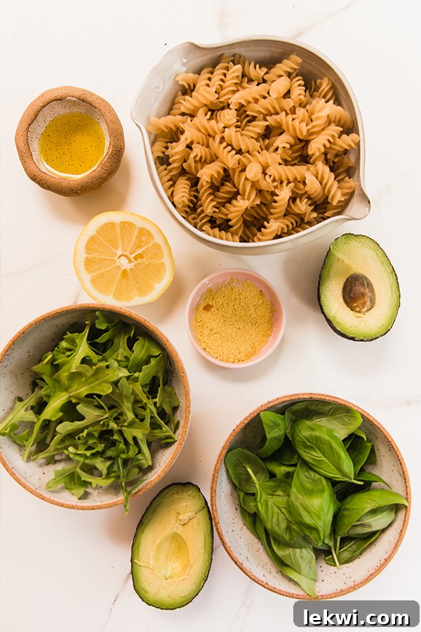 The individual ingredients for avocado pesto pasta laid out on a table.