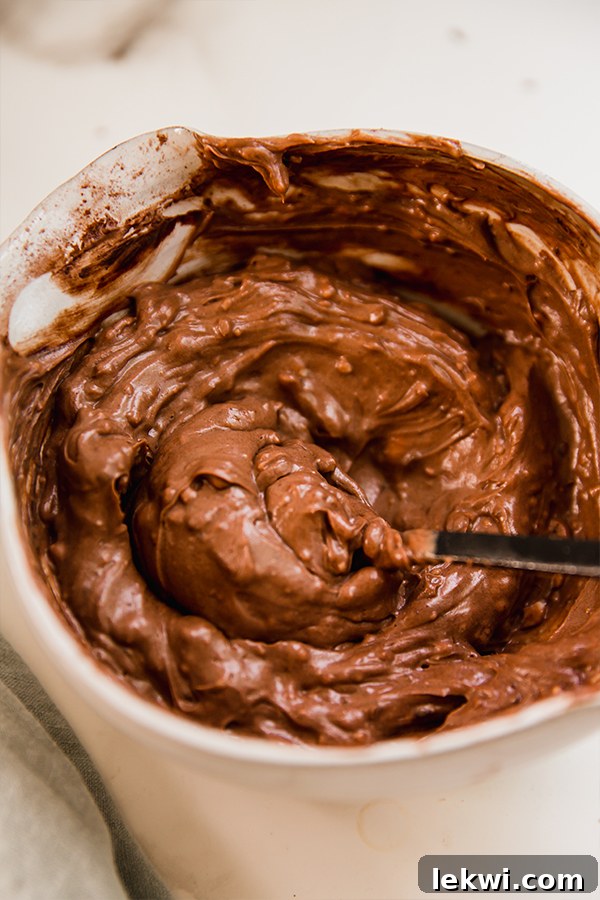 A close-up shot of the rich, smooth chocolate icing, perfectly prepared and ready to be spread over the paleo chocolate cake layers.