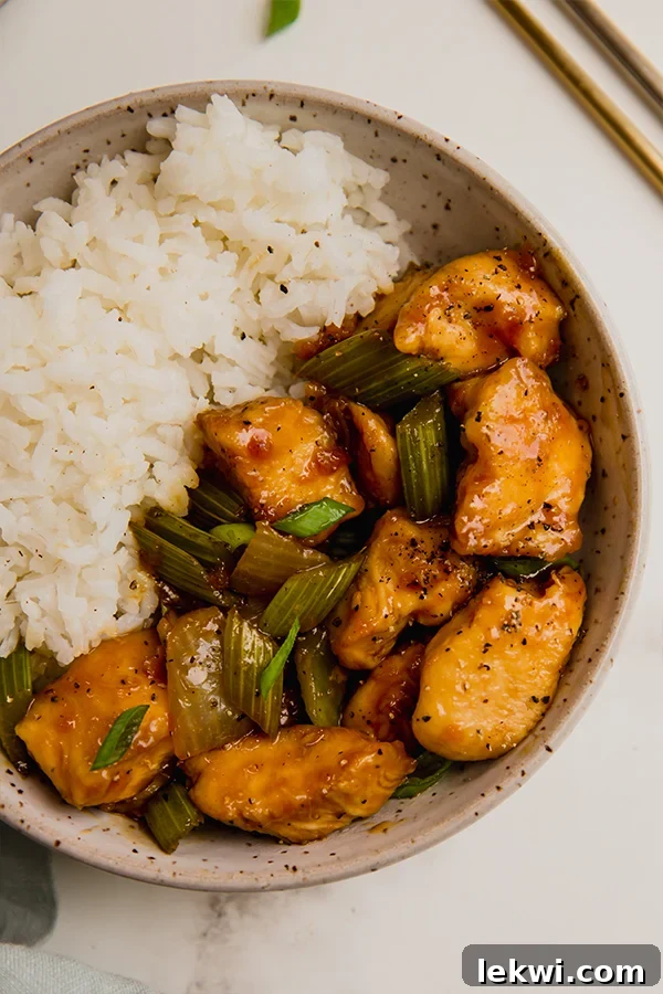 Black pepper chicken stir fry and rice in a bowl.