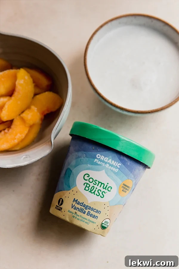 Array of fresh and frozen ingredients laid out for making the dairy-free creamy peach milkshake, including frozen peaches, canned coconut milk, and a container of dairy-free ice cream.