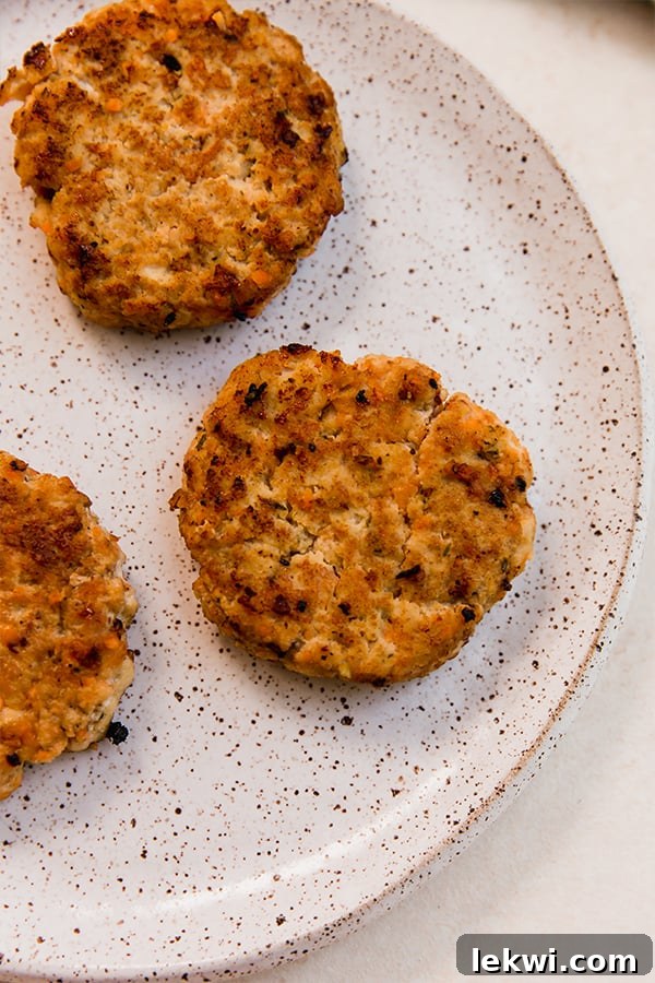 Perfectly cooked breakfast sausages on a plate, ready for assembly.