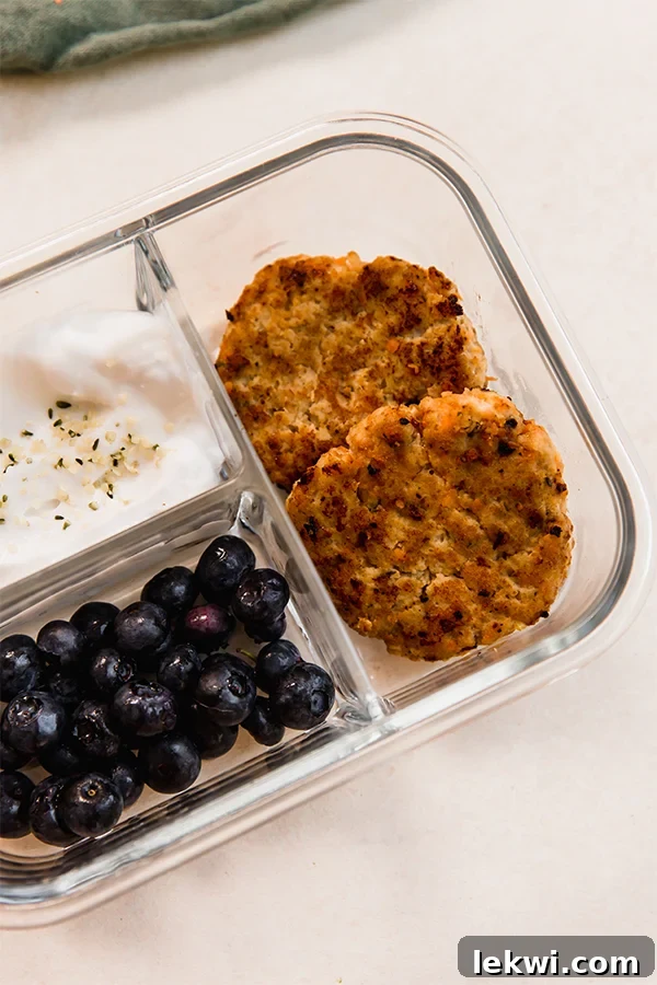 Sausage, coconut yogurt, and blueberries in a divided container.