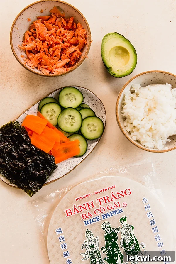 The ingredients for sushi-inspired salmon rice paper rolls, laid out on a table.