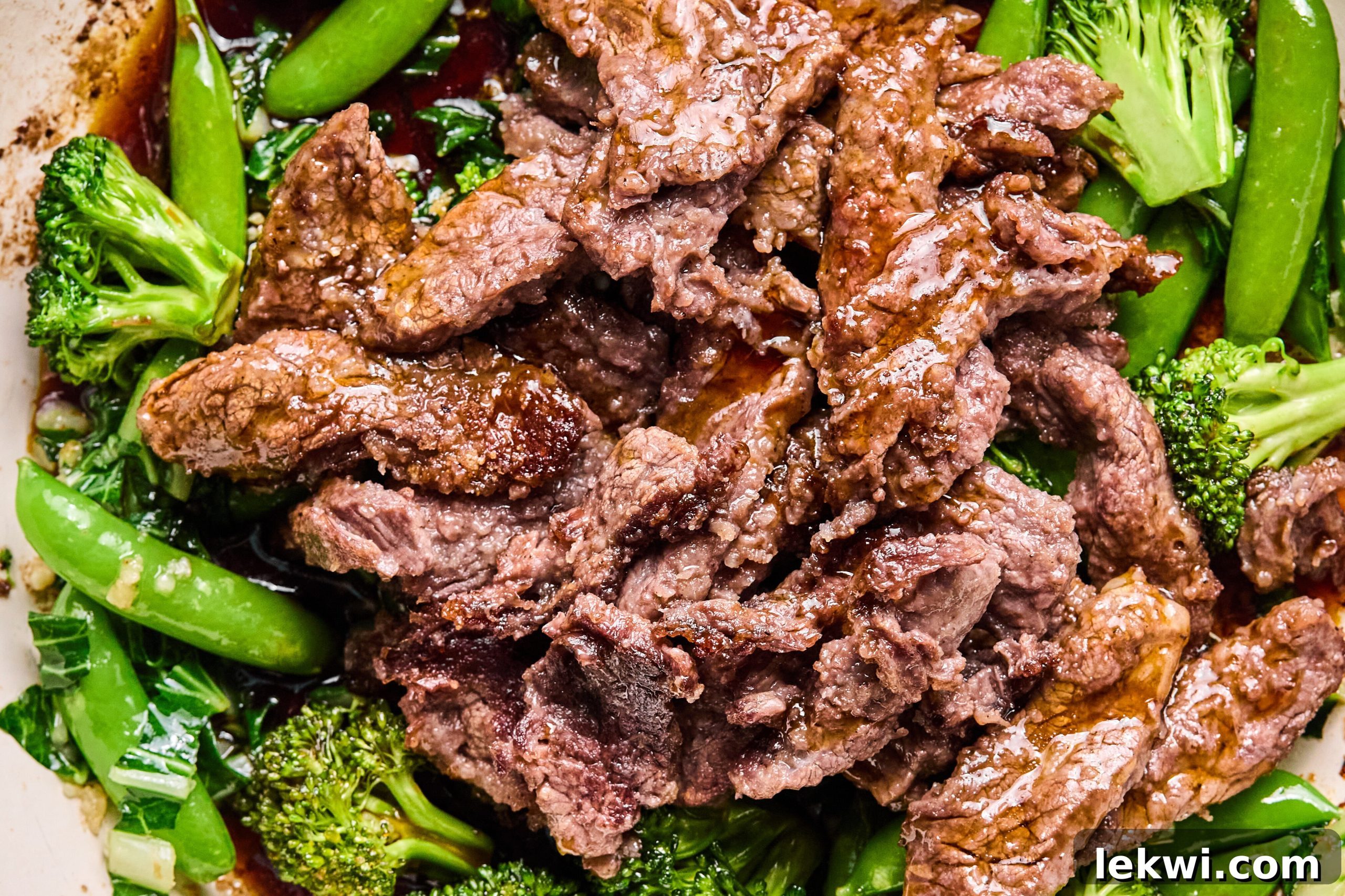 The vegetables and the beef sauting in a pan.