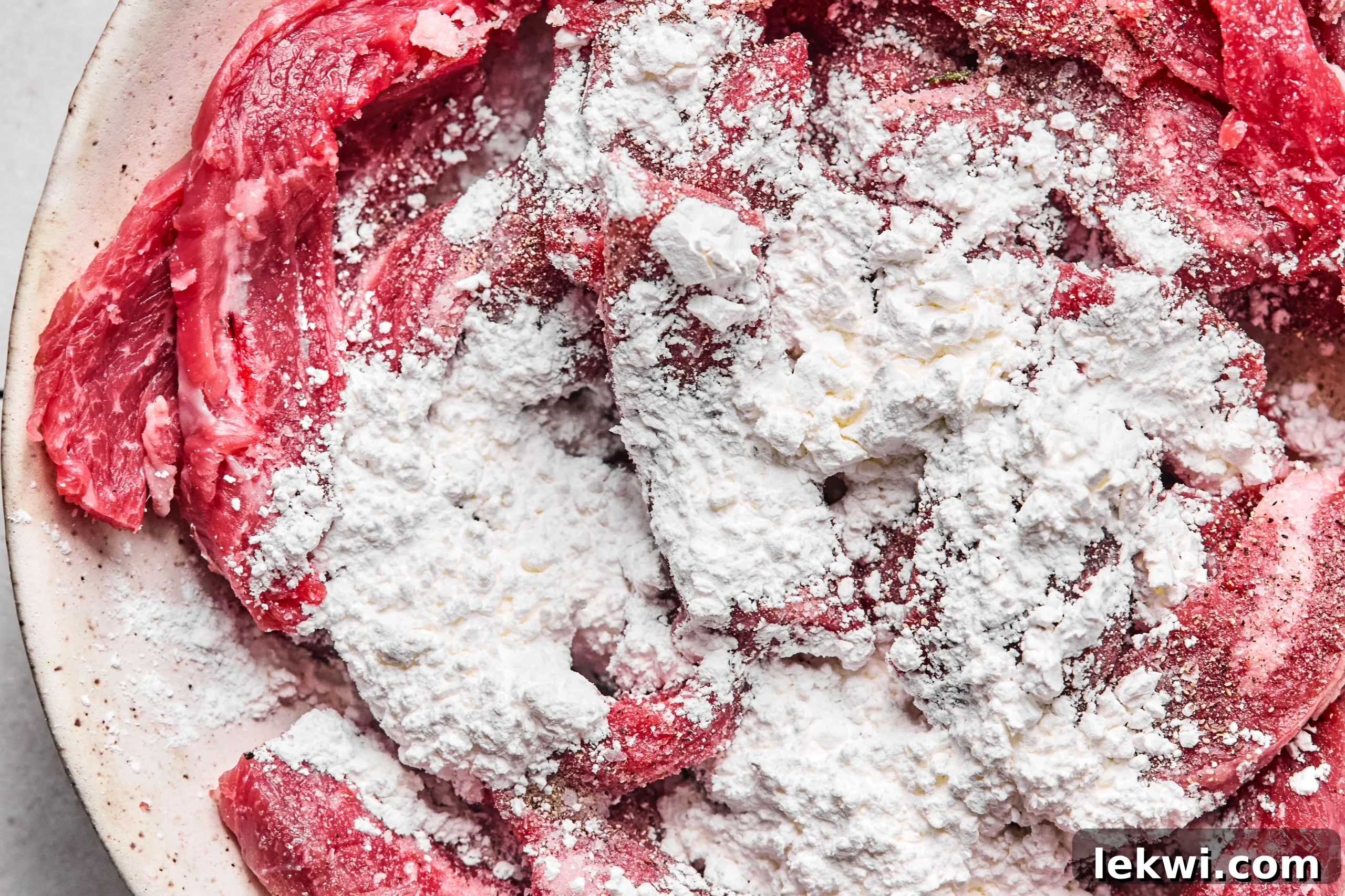 The steak covered in salt, pepper, and arrowroot powder.