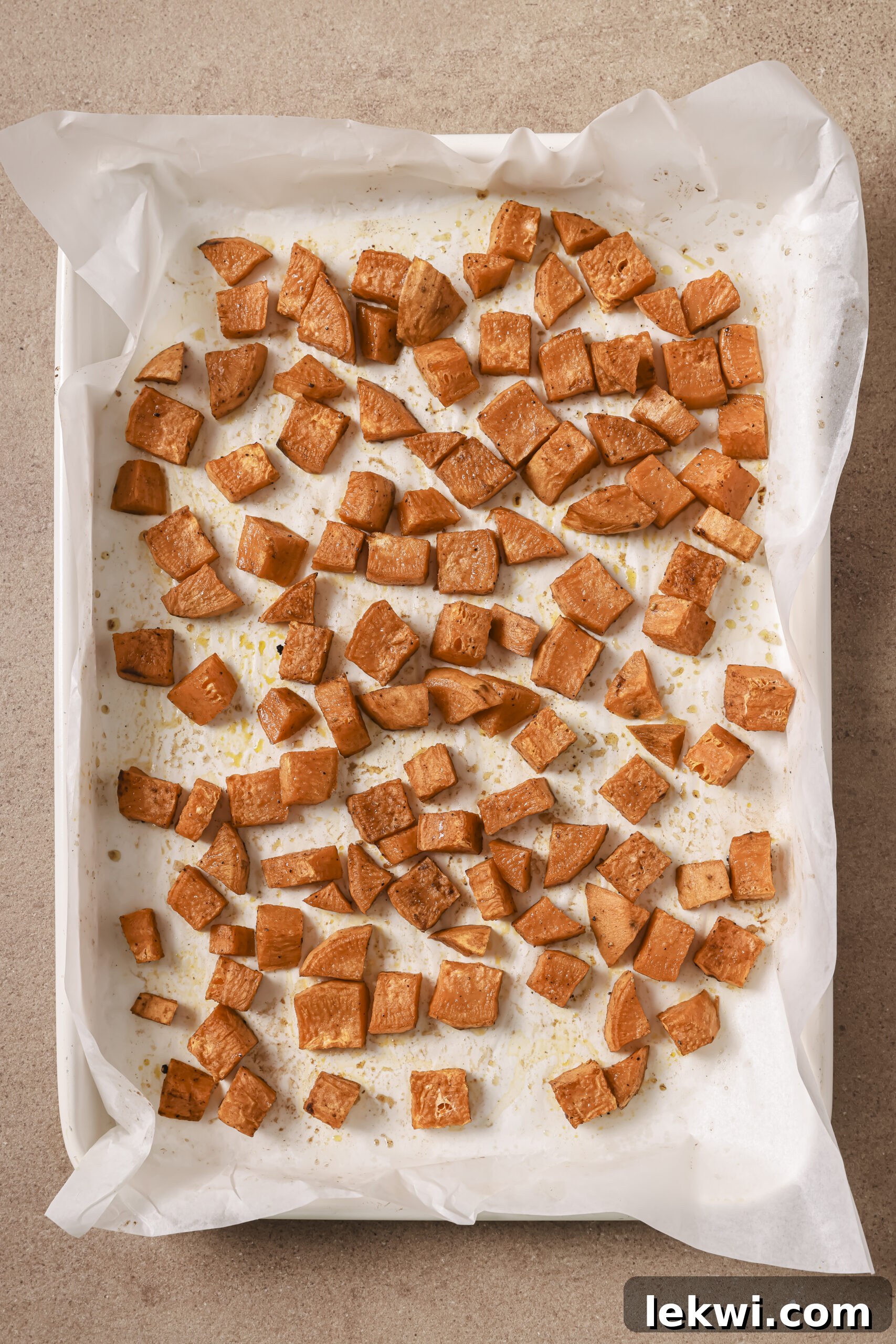 Diced sweet potato cooked on a large baking sheet.