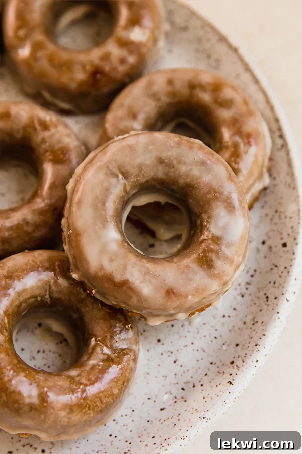 A beautifully arranged platter of grain-free apple cider donuts, dusted with a delicate maple glaze.