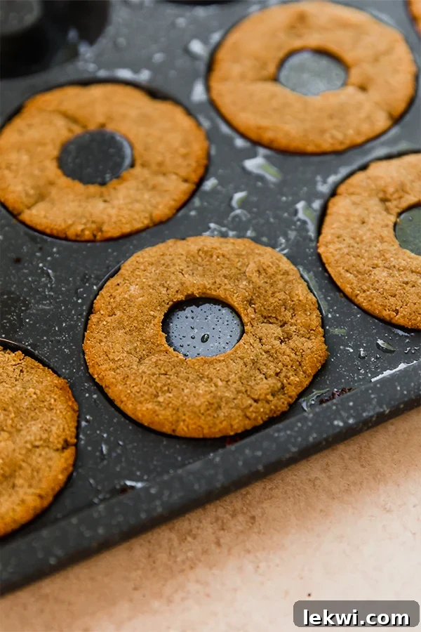 Mini apple cider donuts baking in a non-stick donut pan, showing their perfect golden-brown color.