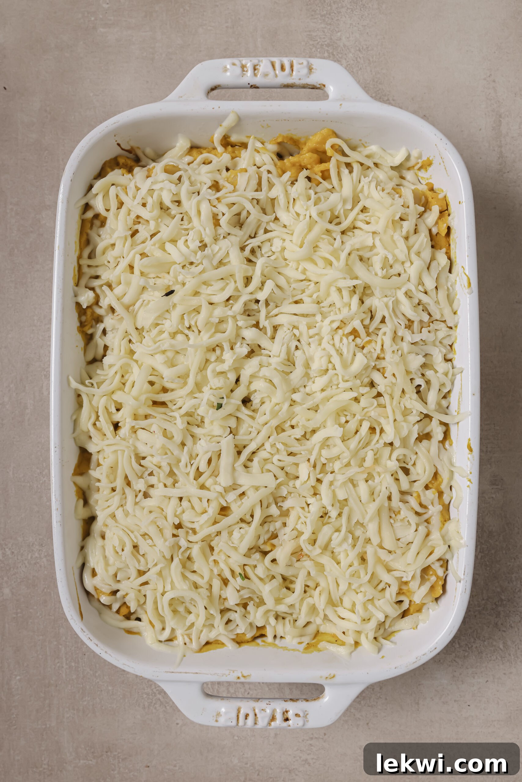 Lasagna roll ups with butternut squash sauce and cheese on top.