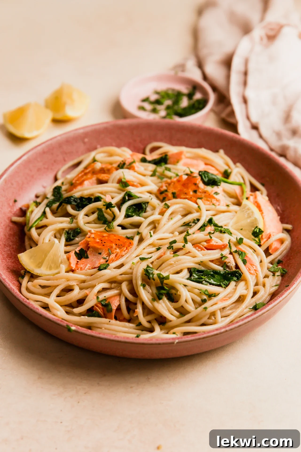 Lemon salmon pasta in a pink bowl.