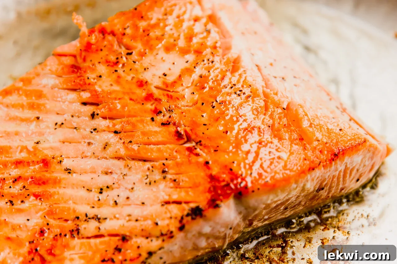 Salmon cooked in a stainless steel pan.