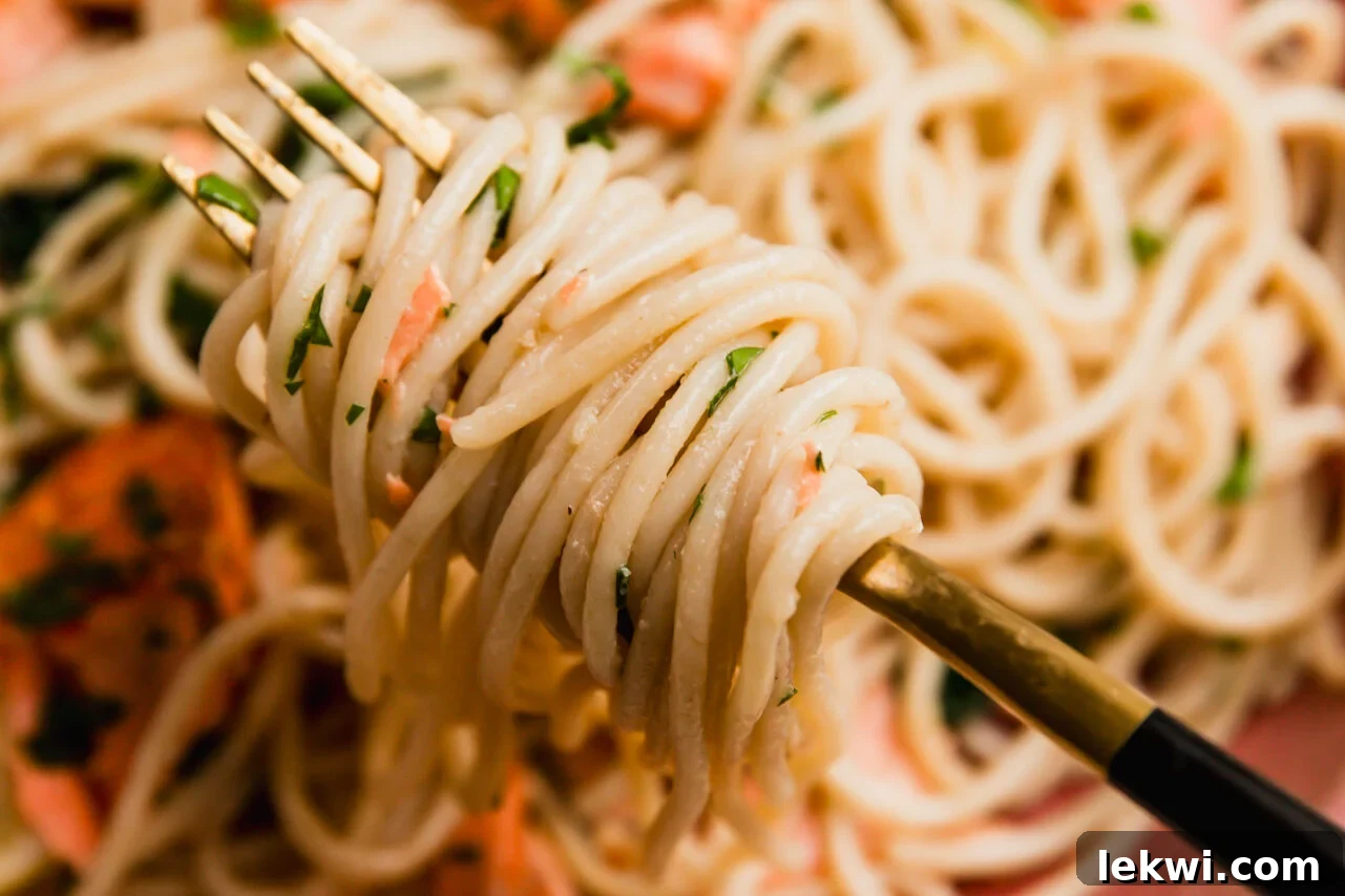Lemon salmon pasta with a fork twirling the pasta.