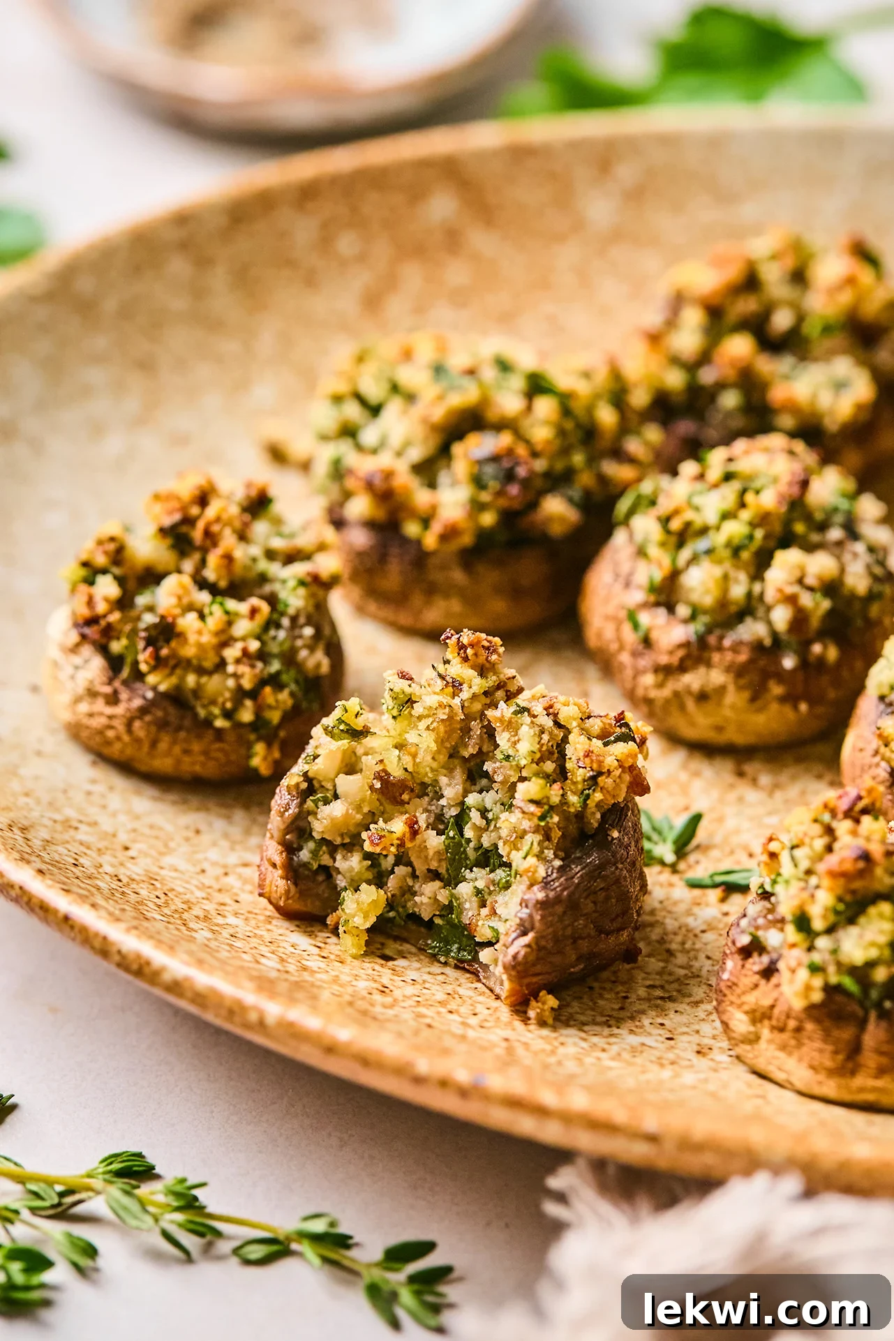 Stuffed mushrooms on a platter with a bite taken out of one.