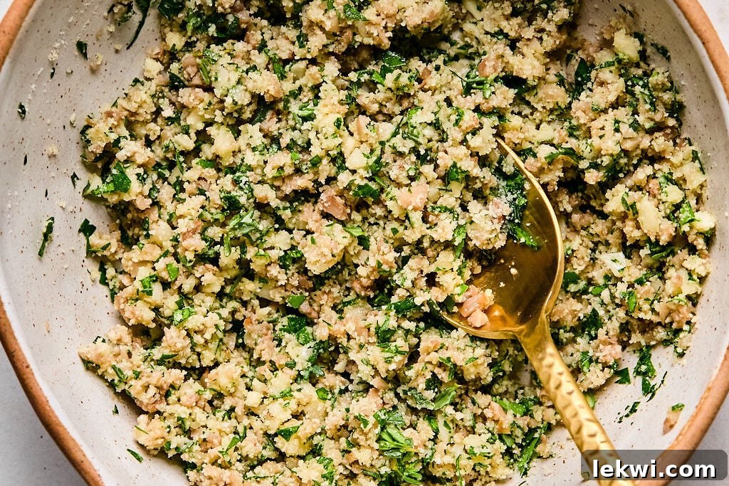 A mixing bowl filled with the savory mushroom filling mixture, combining sautéed stems, herbs, and almond flour.