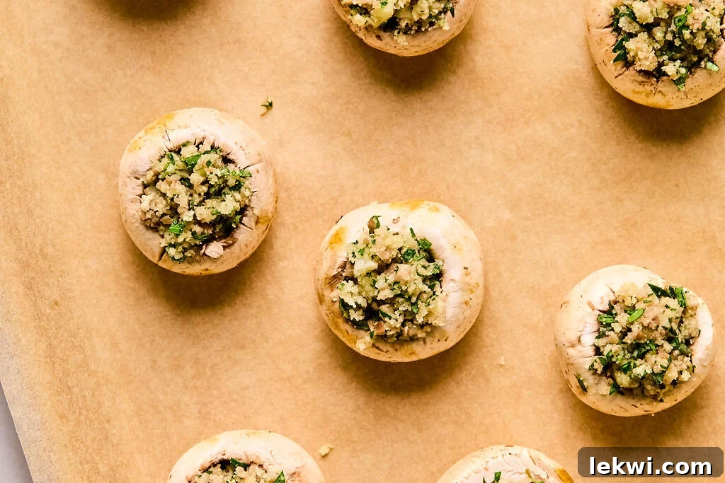 Cleaned mushroom caps carefully stuffed with the savory filling, arranged on a baking sheet and ready for the oven.