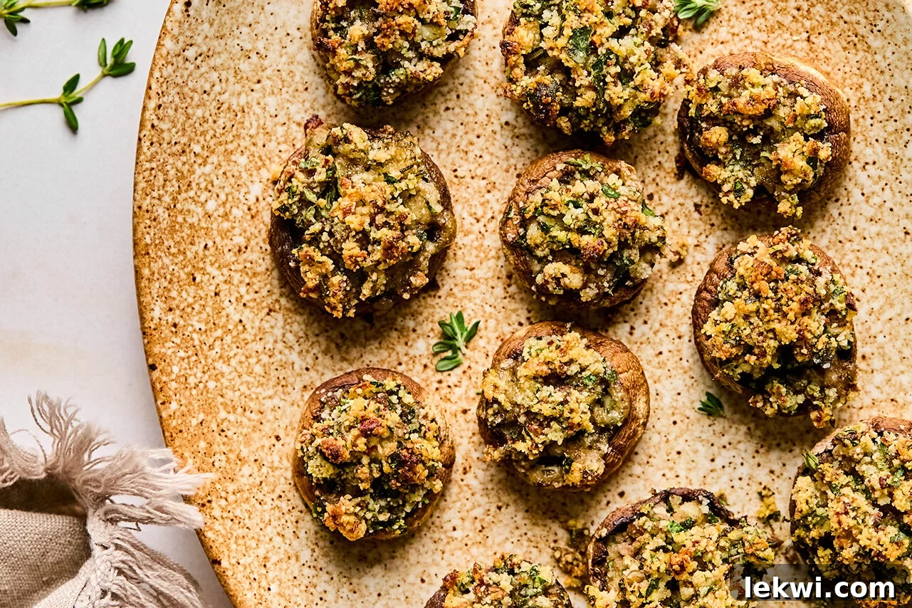 An elegant platter showcasing the finished gluten and dairy-free stuffed mushrooms, garnished with fresh herbs, ready to be served.