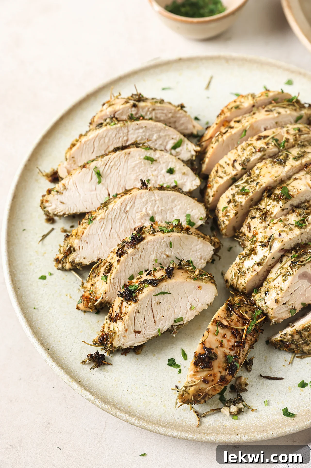 Perfectly sliced turkey tenderloin on a clean white plate, ready to be served.