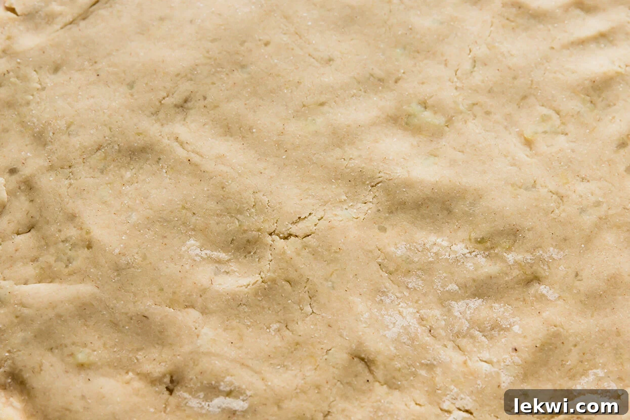 Gingerbread cinnamon dough rolled out evenly on a piece of parchment paper, ready for filling.