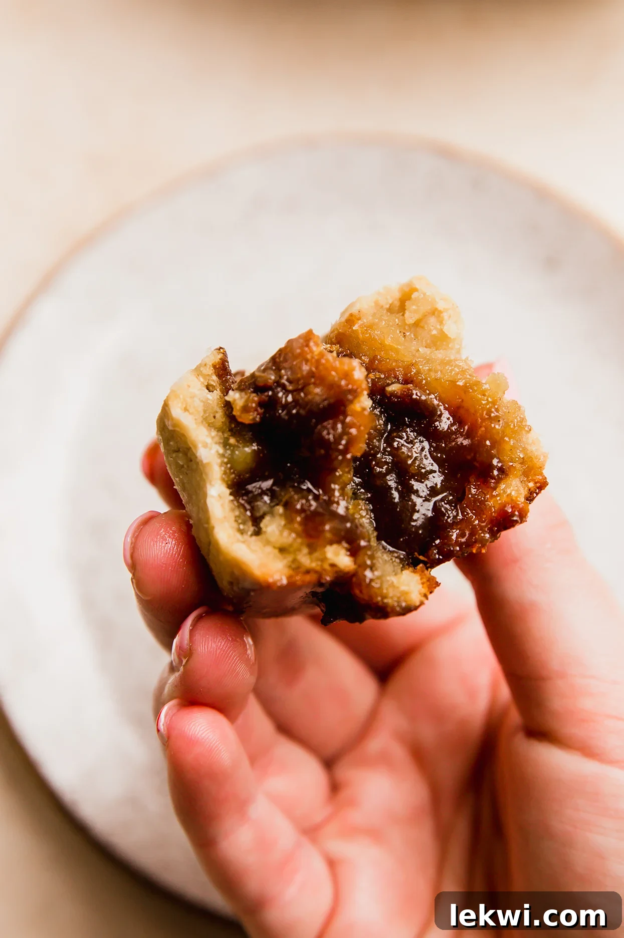 A gooey gluten-free gingerbread cinnamon roll bitten in half, showing the moist, spiced filling and soft texture.