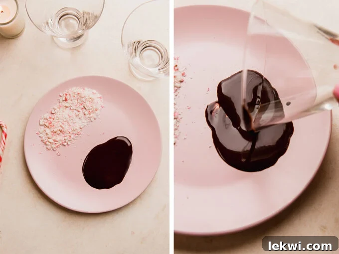 Glass rim being rolled in chocolate on a plate with crushed peppermint candies.