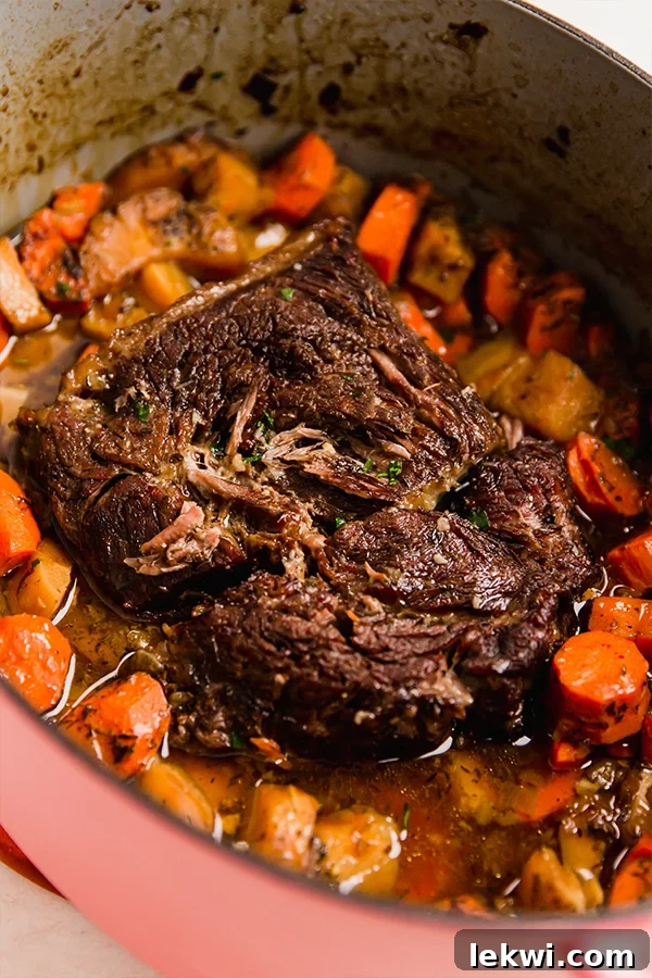The beautiful Dutch oven containing the perfectly oven-baked chuck roast, ready to be served.