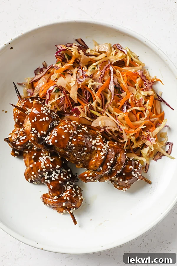 Teriyaki skewers on a plate with slaw.