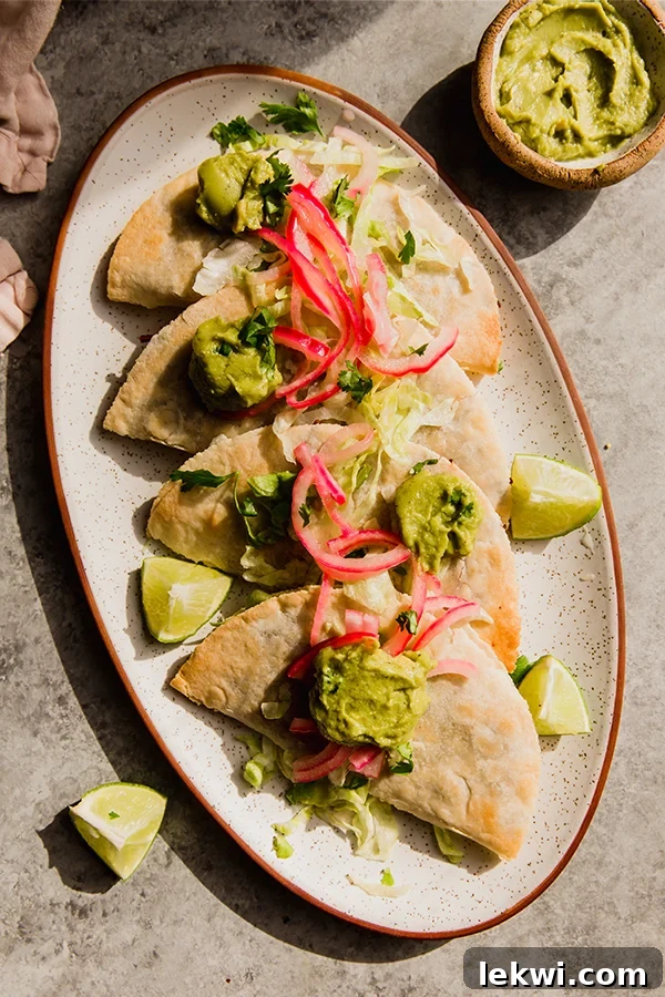 Crispy baked shredded beef tacos arranged artfully on a plate, ready to be served and enjoyed.