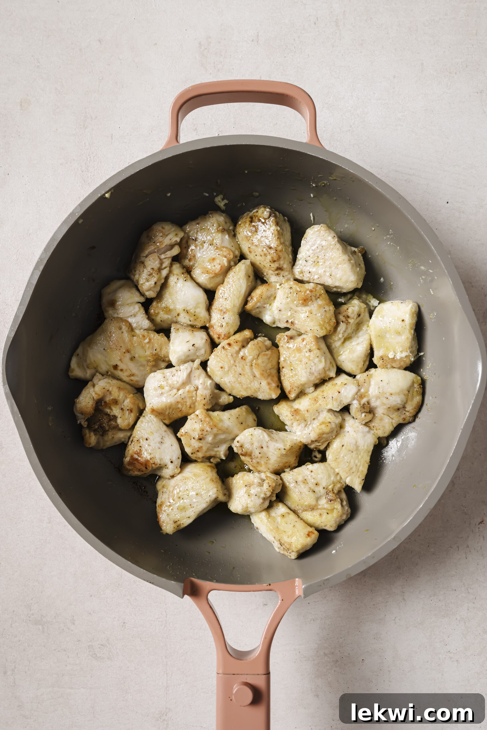 Cooked chicken, cubed in a pan.