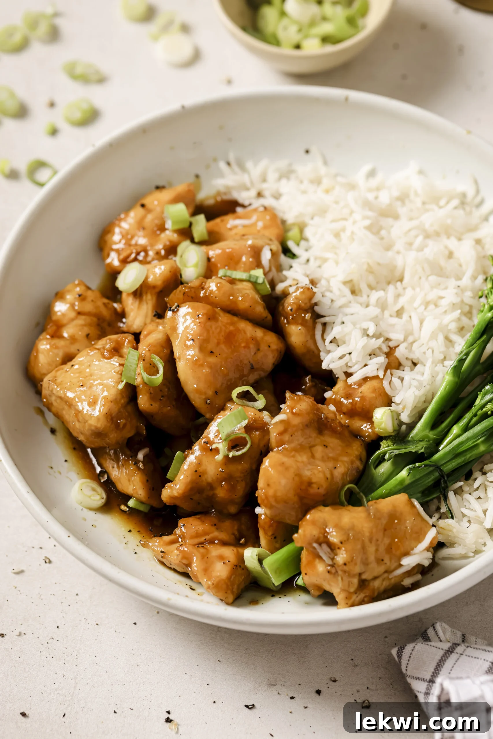 Honey butter chicken bites in a bowl with a side of rice and broccoli.
