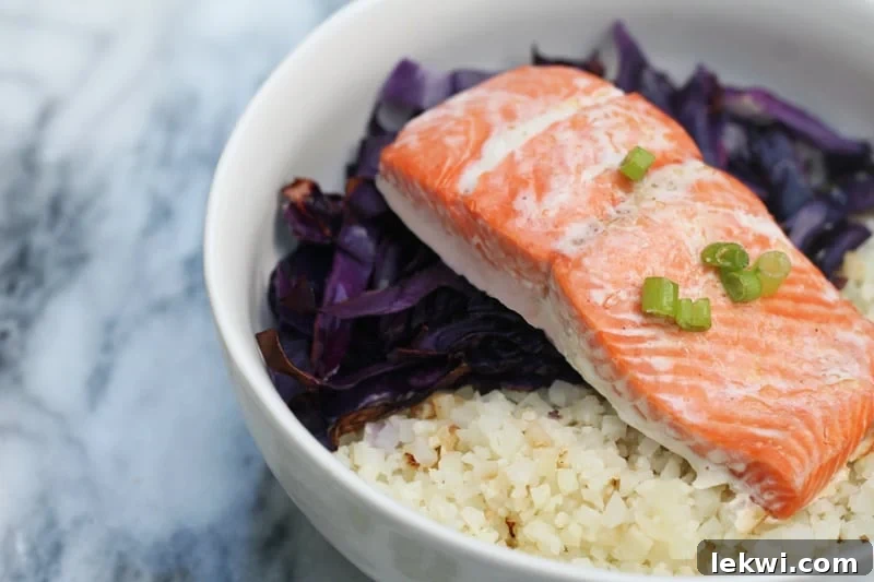 A beautifully composed bowl featuring tender salmon, vibrant purple cabbage, and fluffy cauliflower rice, ready to be enjoyed as a healthy and satisfying meal.
