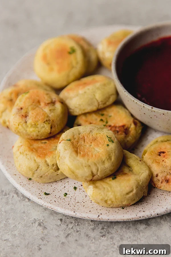 A plate of golden-brown AIP pizza bites, perfectly portioned and ready for dipping, next to a small bowl of nightshade-free dip.
