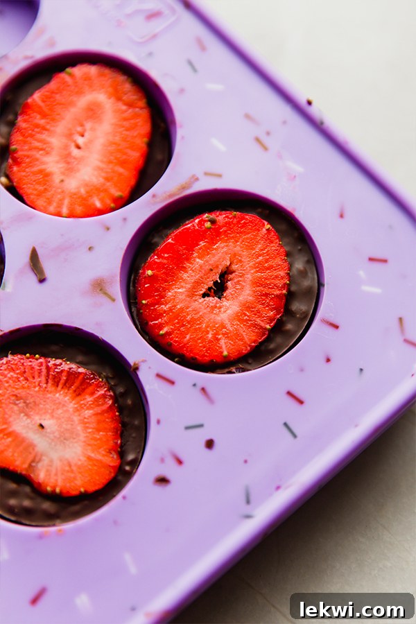 Chocolate strawberry crunch bites in molds from the freezer.