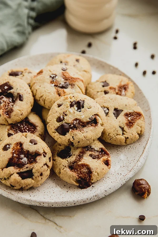 Chocolate chip caramel cookies piled on a plate, ready to be enjoyed.