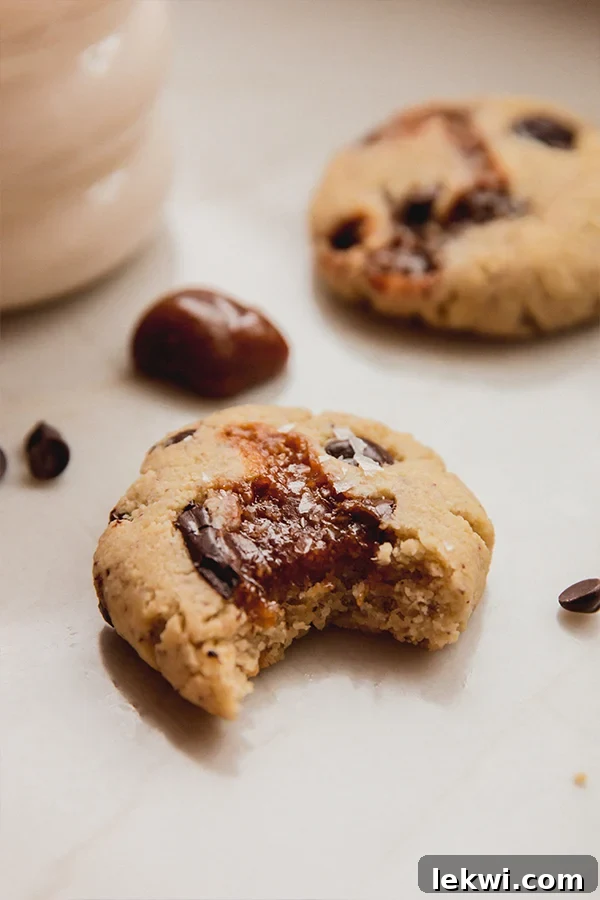 Chocolate chip caramel cookie missing a bite, highlighting the texture.