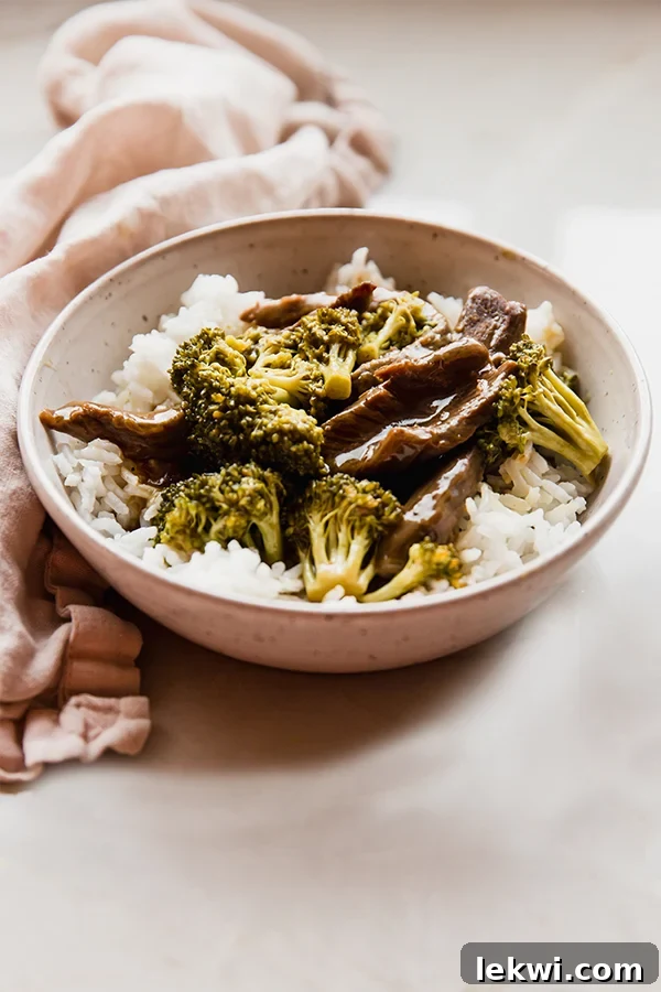 Bowl of orange beef and broccoli with rice. A vibrant and appealing dish ready to be enjoyed.